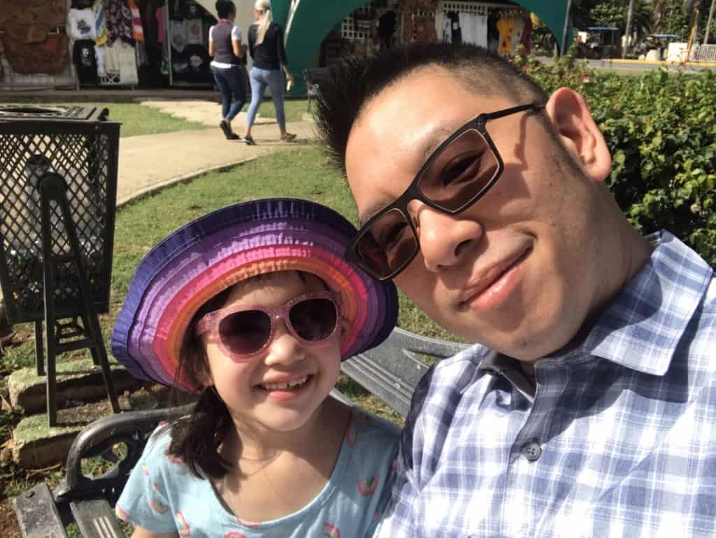 Dad & young girl in sunglasses smiling at market in Varadero Cuba. 