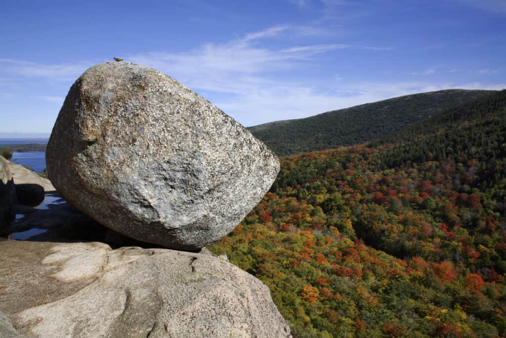 South Bubble Trail, Acadia Park. Bubble ROack on the edge of the cliff looking over fall foliage forest.