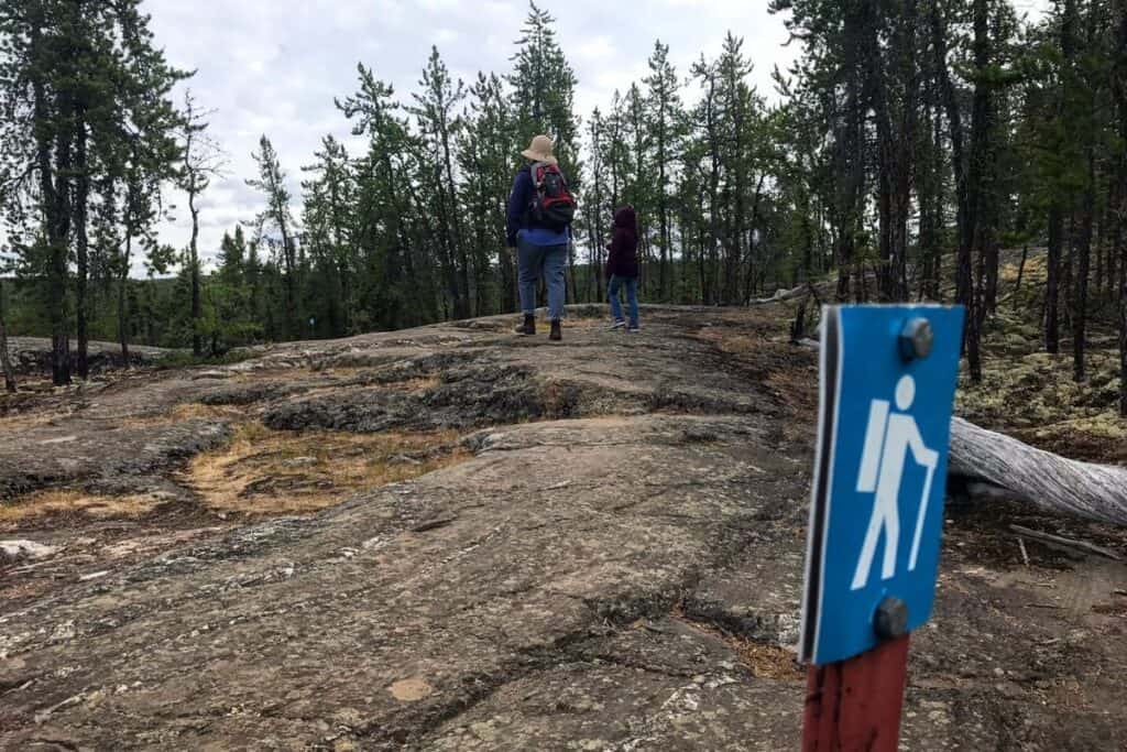 Picture of a mom and daughter wlaking over rocks during the Cameron Falls Hike. 