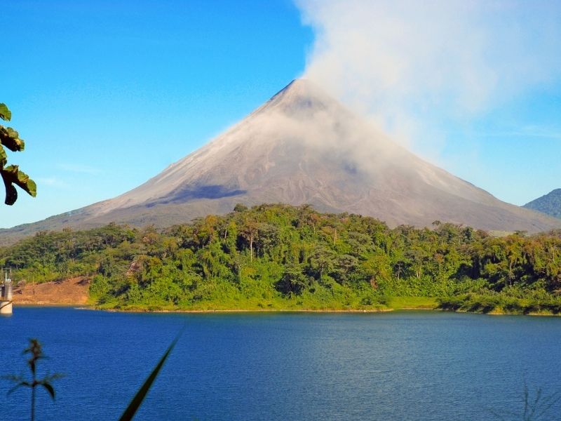 Arenal Volcano in distance with lake in front. Costa Rica itinerary