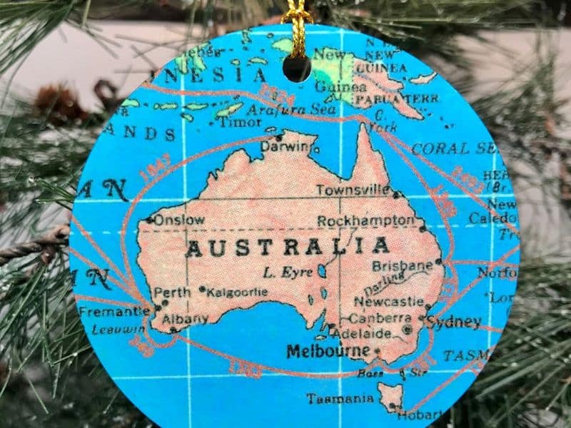Christmas ornament with a map of Australia, hanging on a tree. 