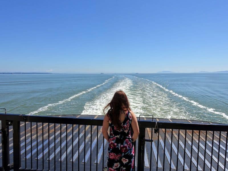 Woman from behind facing the wake of the ferry near Tsawwassen Ferry Terminal.