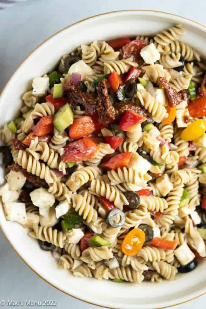 Mediterranean pasta salad made with rotini pasta, cherry tomatoes, cucumbers, red onion, black olives, sun-dried tomatoes, and cubes of cheese tossed in a light vinaigrette. A colorful, flavorful dish perfect for potlucks, picnics, or easy meal prep.