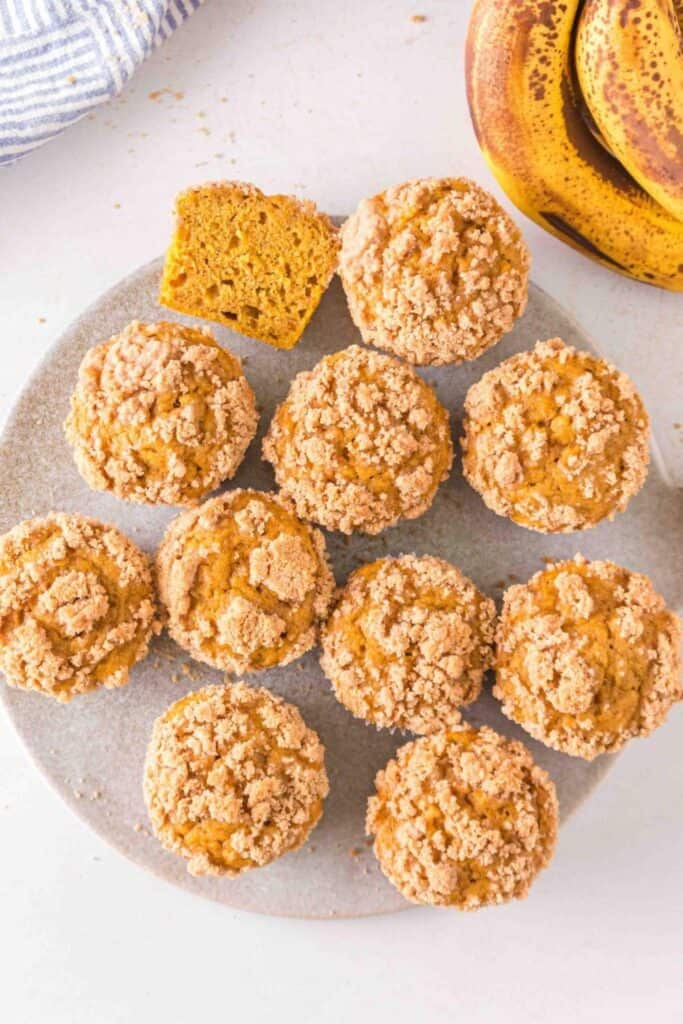 Overhead view of a plate of Banana Pumpkin Muffins with crumble top. 