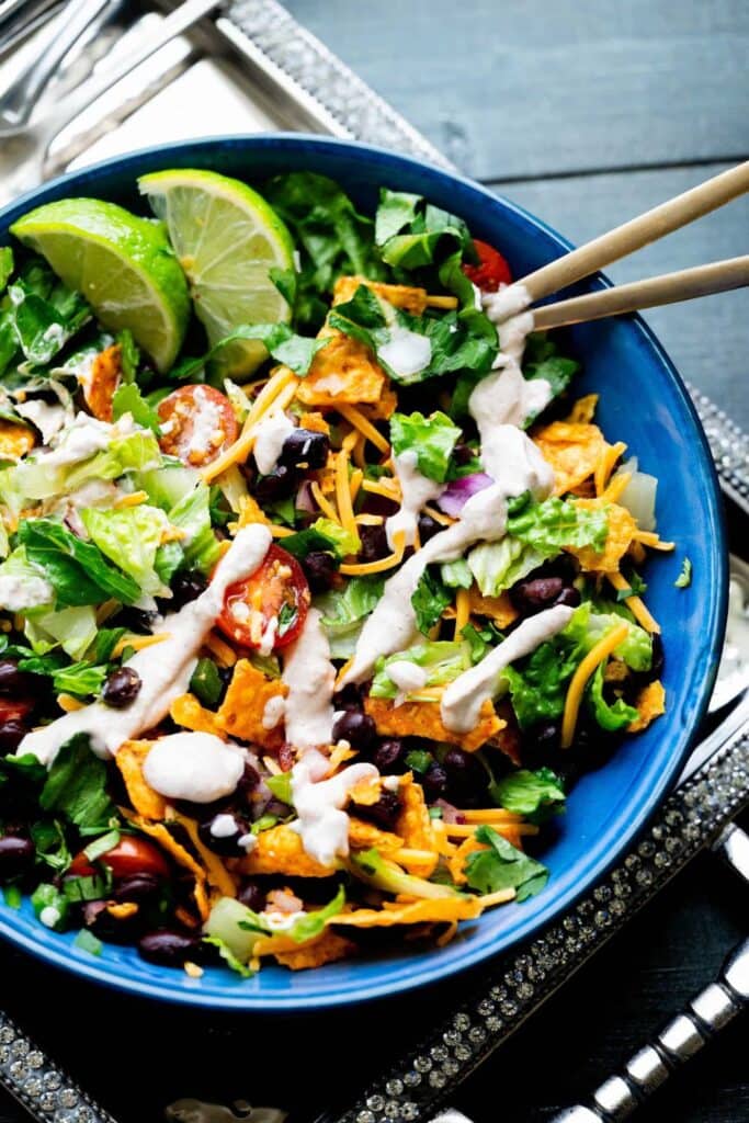 Bowl of green leaf lettuce sald with dirot chips, shredded cheddar cheese and black beans. 