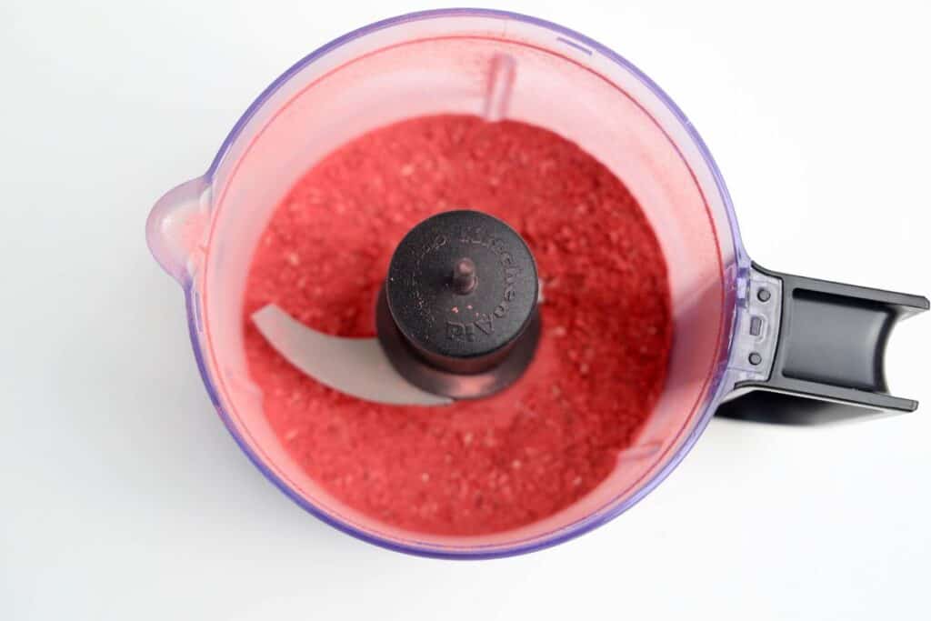 Overhead view of food processor with blended freeze dried strawberries.