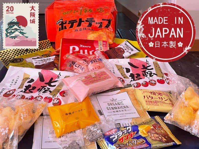 10 Japanese snacks and Genmaicha tea packet in a pile from the Bokksu subscription box. 