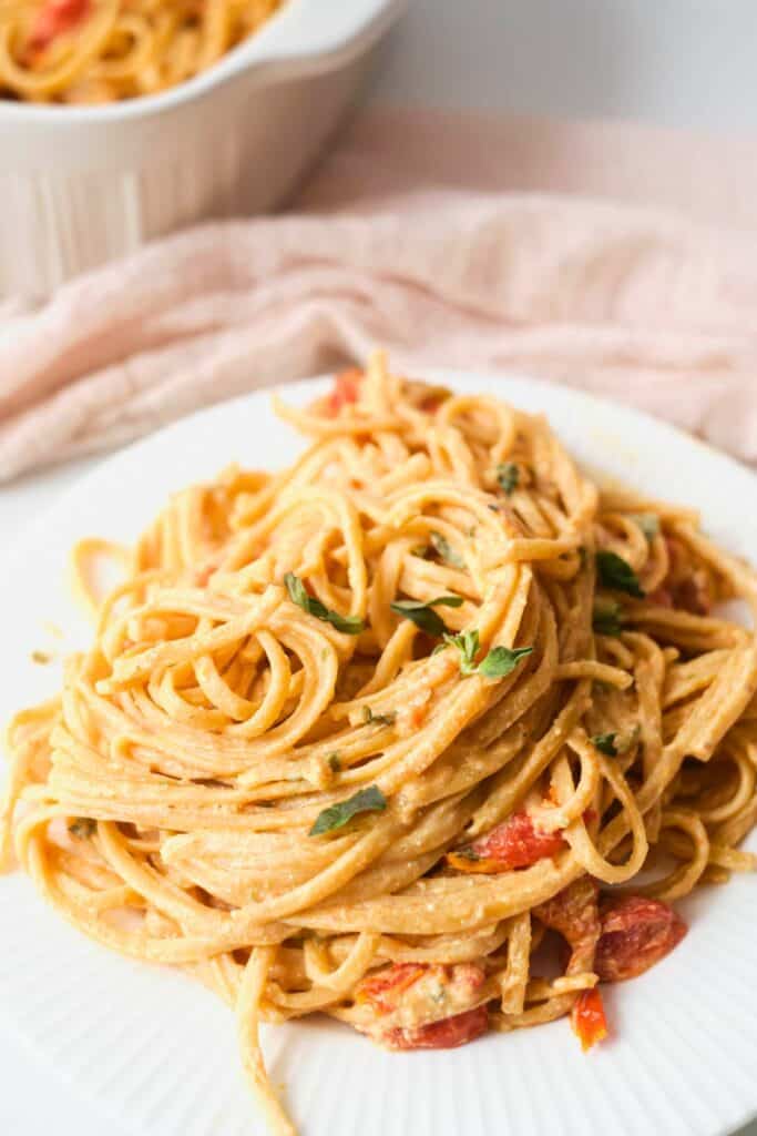 Boursin cheese pasta with spaghetti coated in a creamy herb cheese sauce and tossed with roasted tomatoes. The pasta is plated in a generous twirl and garnished with fresh herbs, making it an easy 30 minute meal for busy weeknights.