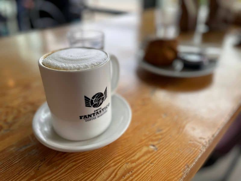 Cafe Fantastico Coffee cup on wooden table. 