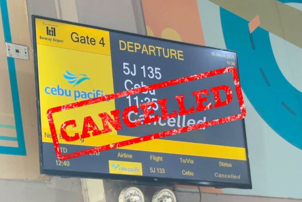 Airport departure board at Boracay Airport Gate 4 showing Cebu Pacific flight 5J 135 to Cebu marked as cancelled with a large red Cancelled stamp across the screen signaling disrupted travel plans.