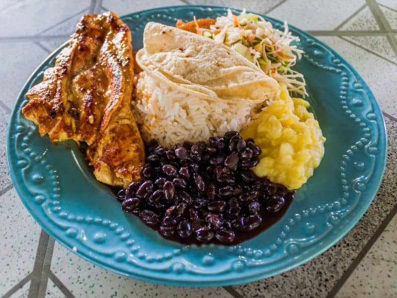 Traditional Costa Rican meal "casado on a plate. Beans, rice chicken and coleslaw. 