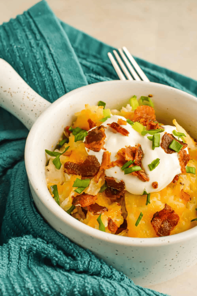 Round small dish with chicken, hasbrown casserole topped with bacon bits and sour cream