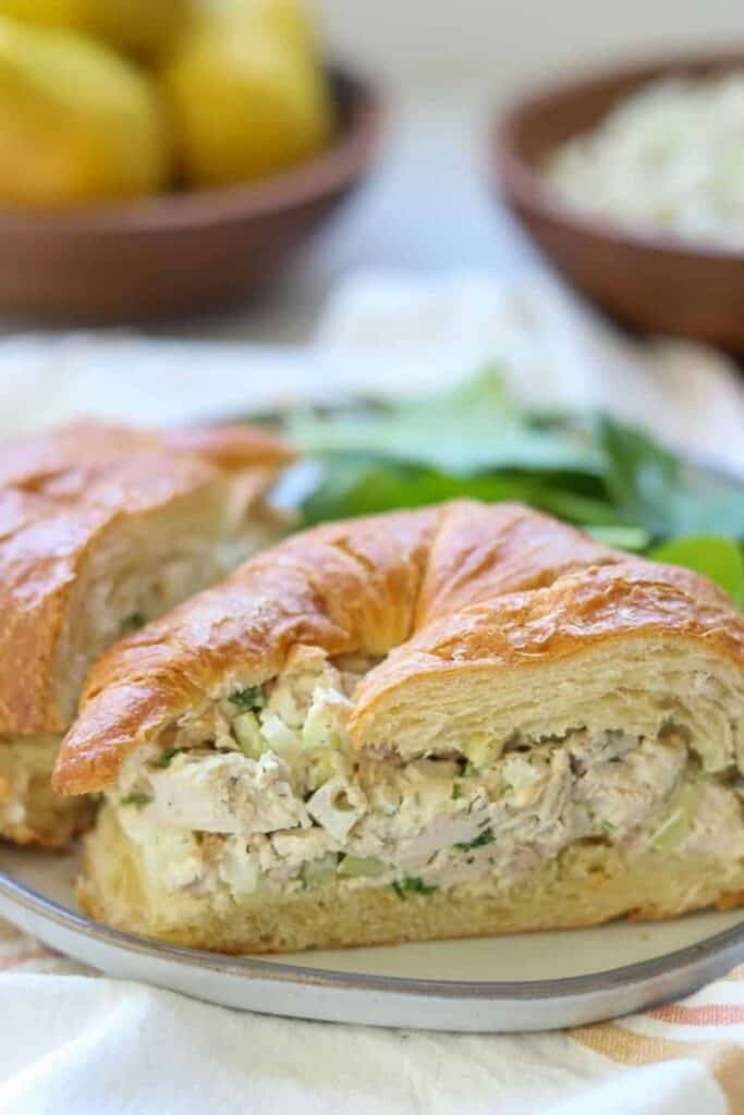 Croissant sandwhiches with chicken salad and lettuce on a plate. 