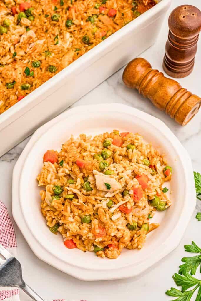 Chicken and rice casserole with shredded chicken, fluffy rice, green peas, diced carrots and fresh parsley, a hearty addition to 9 x 13 casseroles.