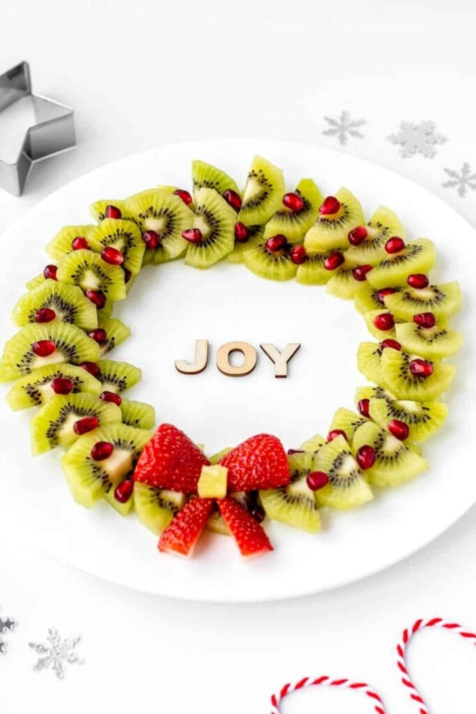 Christmas wreath made out of kiwis, strawberries and pomegranate seeds. 