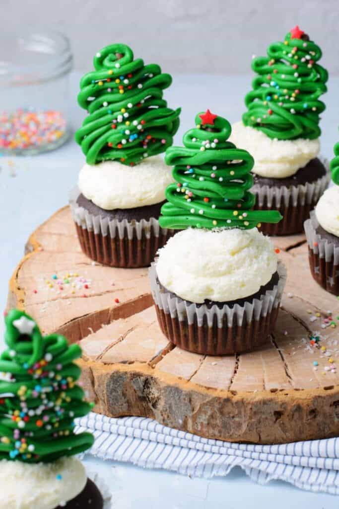 3 Chocolate cupcakes topped with white icing & coconut "snow" with green candy christmas tree. 