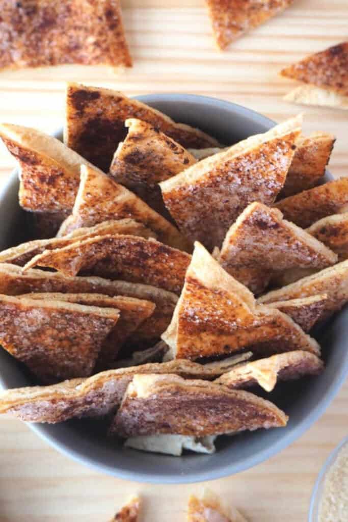 Bowl filled with triangles of cinnamon sugar pita chips. 