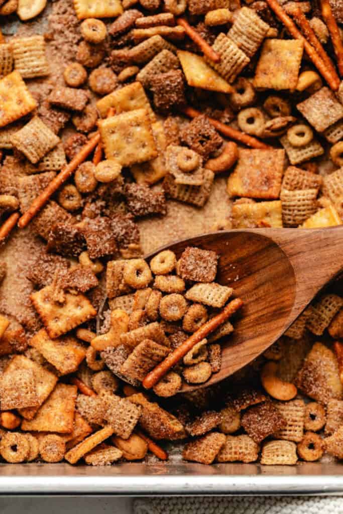 A tray of sweey and salty chex mix with mini crackers, cheerios, pretzel sticks and cashews, 