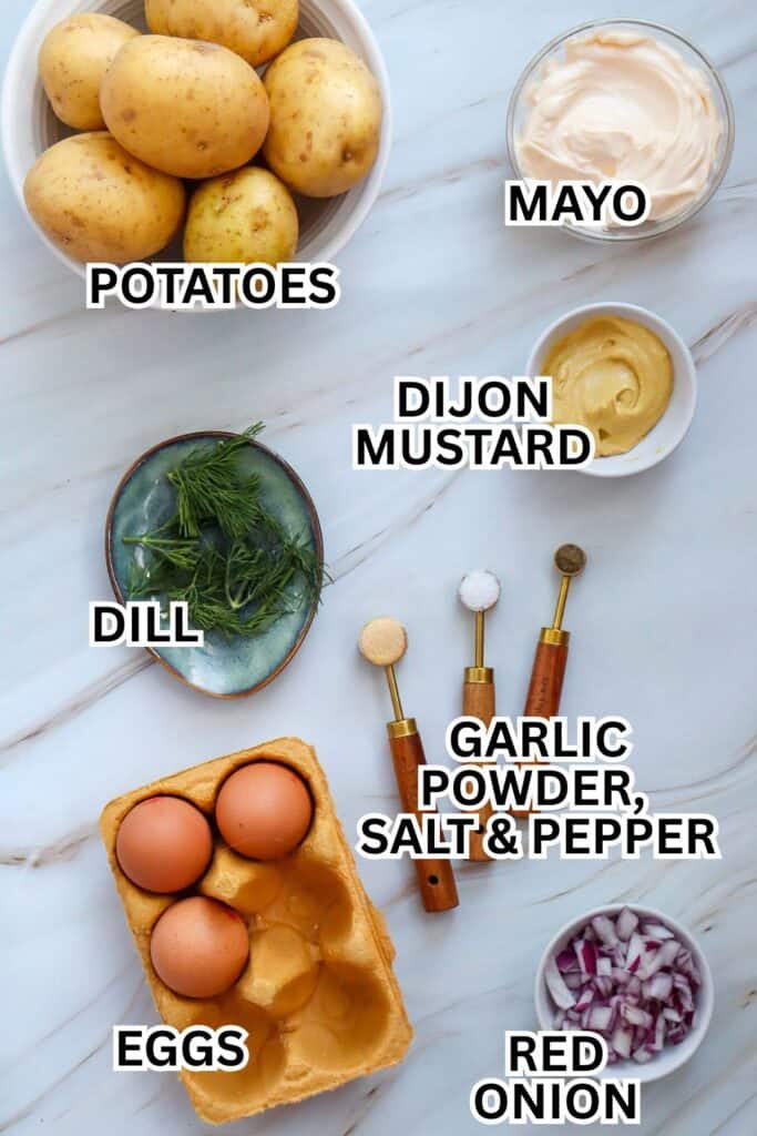 Cold potato salad ingredients laid out in small dishes on a marble counter top. 