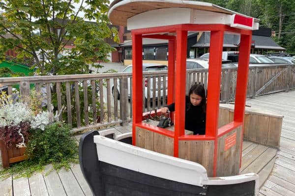 Young girl playing on a kid size boat on the Cowichan Bay Maritime Centre deck.
