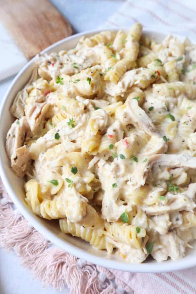 Close up of a bowl of Crockpot Garlic Parmesan Chicken over rotini noodles. 