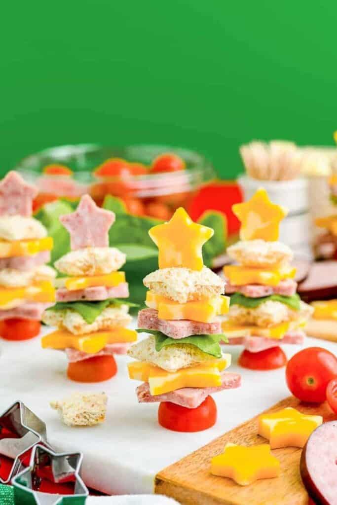 Mini toothpick skewers with star shaped bread, cheese, meat on them.