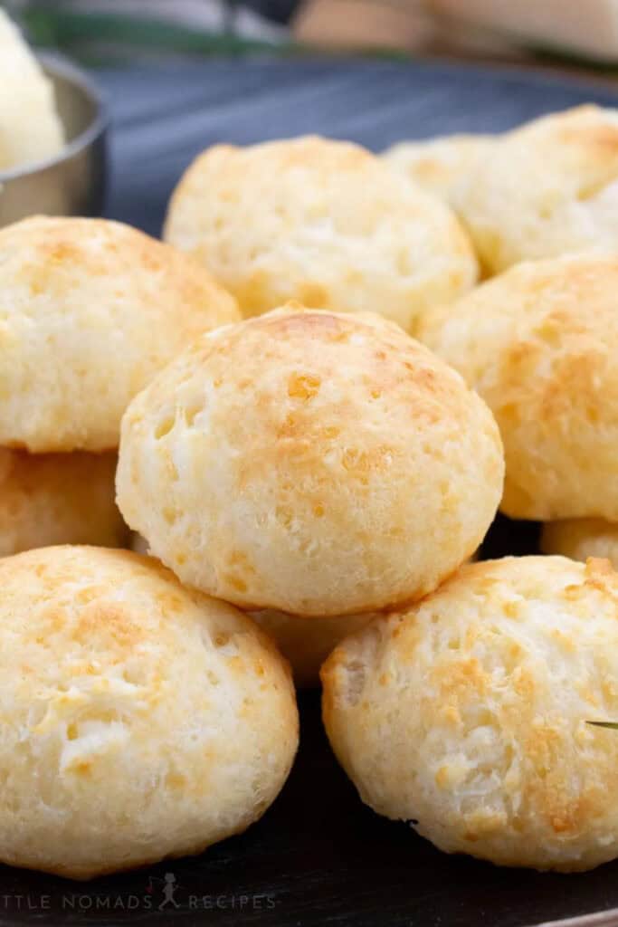 A close up of a pile of round Brazilian Cheese Buns. 