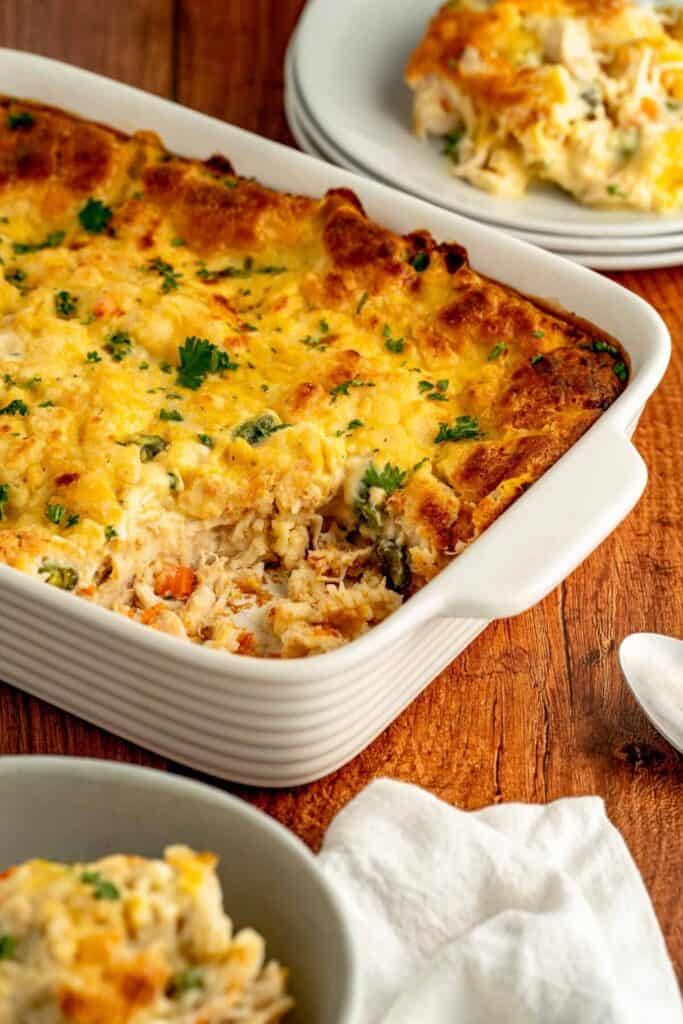 Creamy chicken and vegetable casserole topped with golden cheesy biscuits and fresh parsley, an inviting choice for easy fall casseroles on cozy family dinner nights.