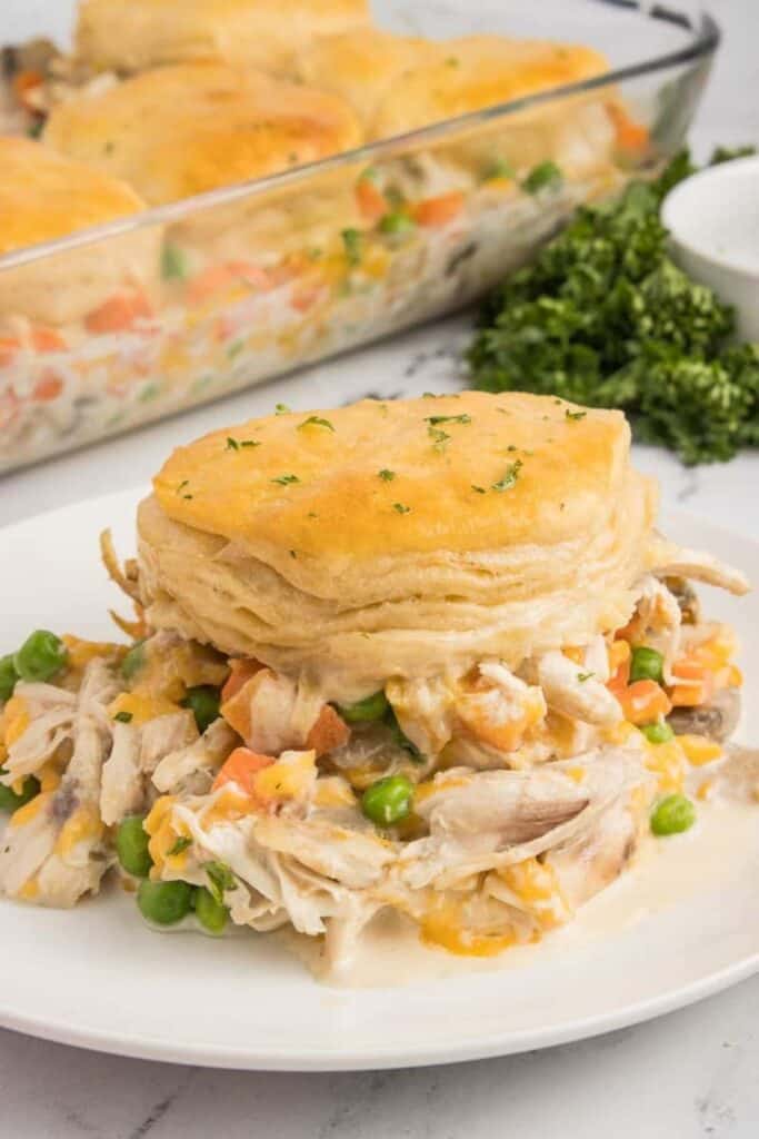 Plate with a serving of chicken pot pie casserole topped with a flaky biscuit. 