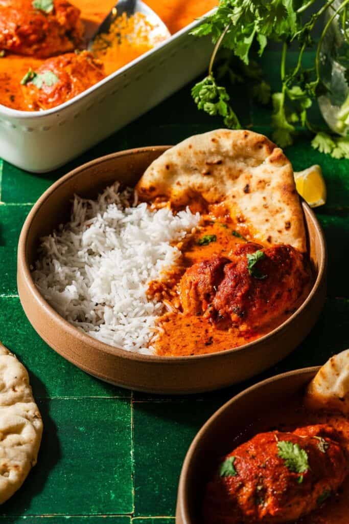 Round dish of easy butter chicken & rice with naan.