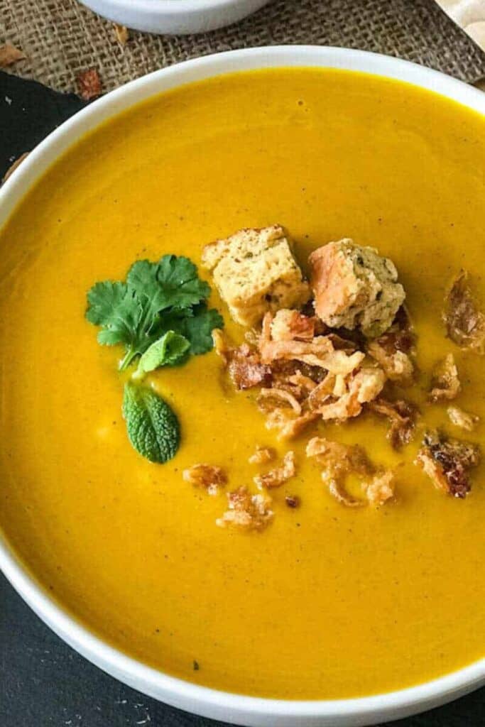 Bowl of creamed sweet potato, tumeric, coconut milk soup. 