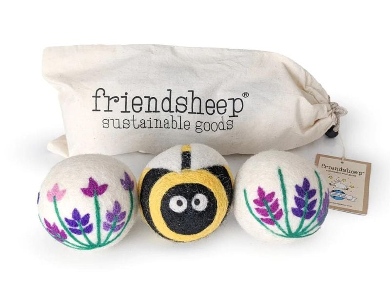 Three wool dryer balls, a bee and 2 with flowers from friendsheep sustainable goods.