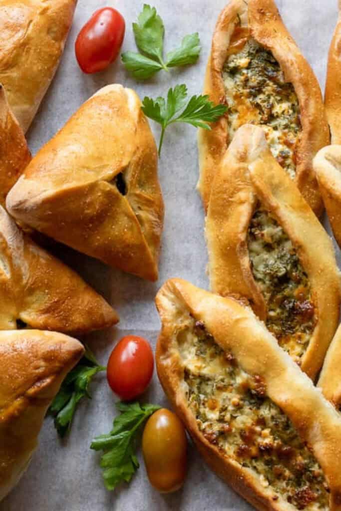 Fatayer, Lebanese stuffed bread in triangle shapes, and open faced to show the spinach and cheese mix. 