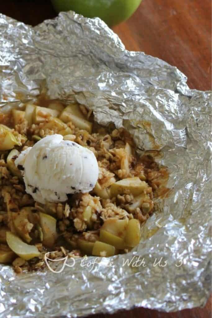 Open tin foil packet with granola, green apple slices and caramel sauce. 