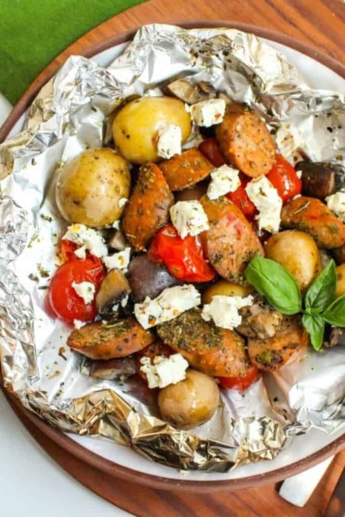 Round foil pouch filled with italian sausage slices, baby potatos, red pepper, topped with feta and fresh basil. 