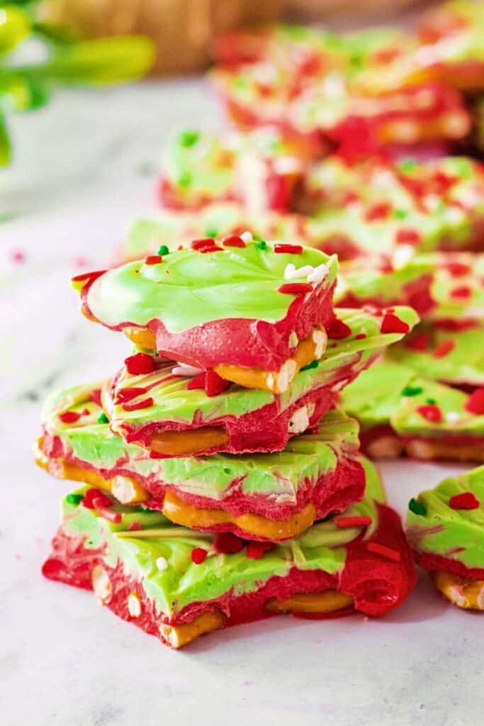 Pieces of red and green Grinch pretzel bark stacked up.