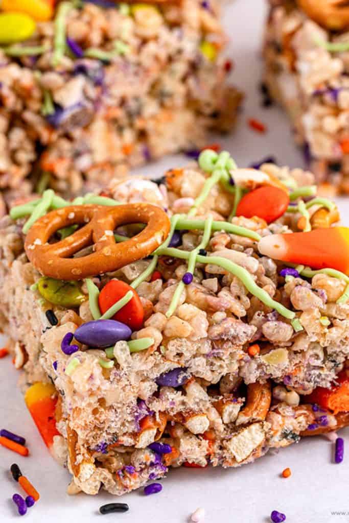 Halloween Rice Krispies treat bar topped with candy corn, pretzels, colorful candy-coated chocolates, sprinkles, and drizzles of green icing.