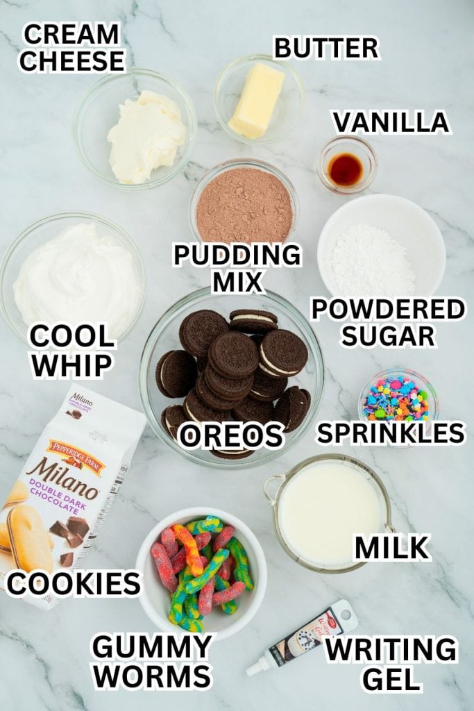 Flat lay of ingredients for making Halloween dirt pudding cups, including bowls of cream cheese, Cool Whip, butter, chocolate pudding mix, powdered sugar, vanilla extract, milk, Oreos, colorful sprinkles, gummy worms, Milano cookies, and a tube of black writing gel, all labeled with bold text.