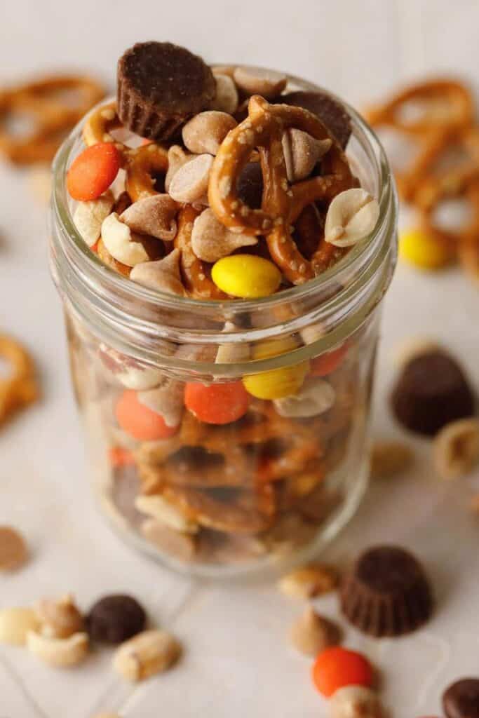Mason Jar filled with Halloween Trail mix; pretzels, reeses pieces, chocolate chips, cashews