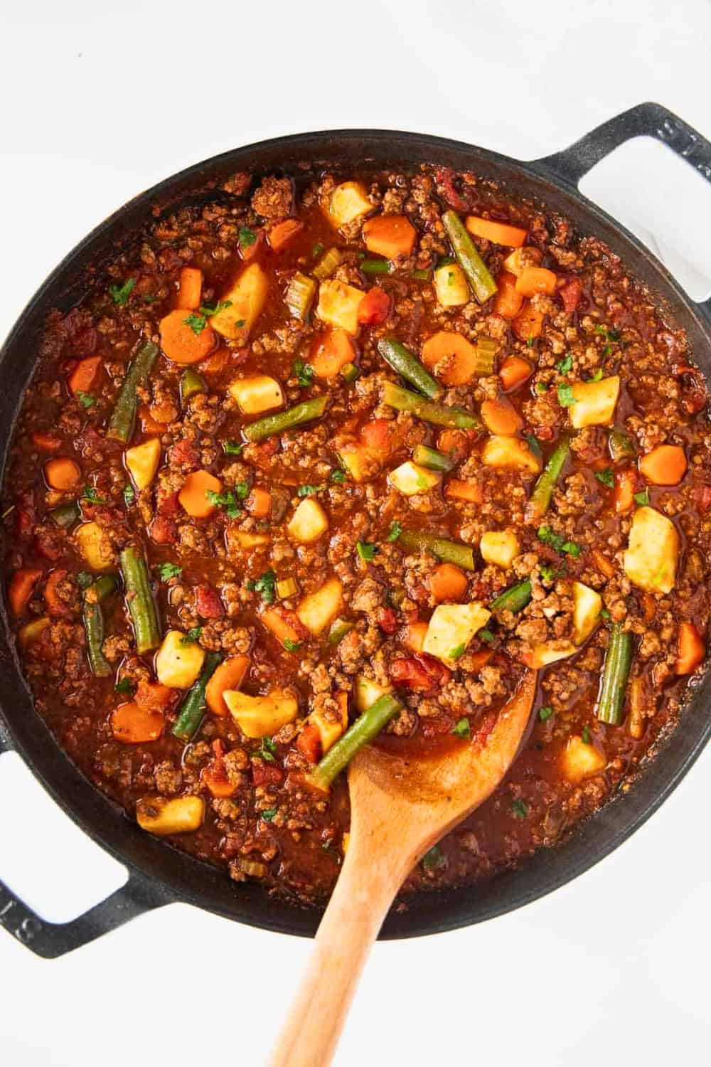 Hamburger soup with ground beef potatoes carrots green beans and celery simmers in a rich tomato broth. This hearty dish is an easy option for quick ground beef soup recipes.