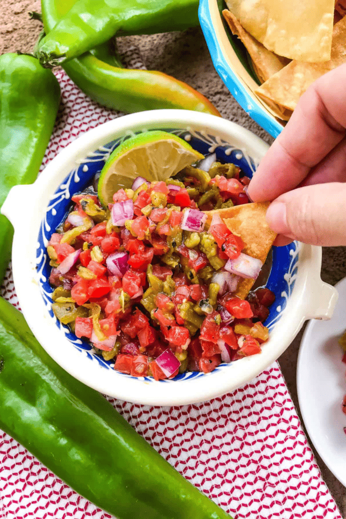 Bowl of pico de gallo with a slice of lime on the side. 