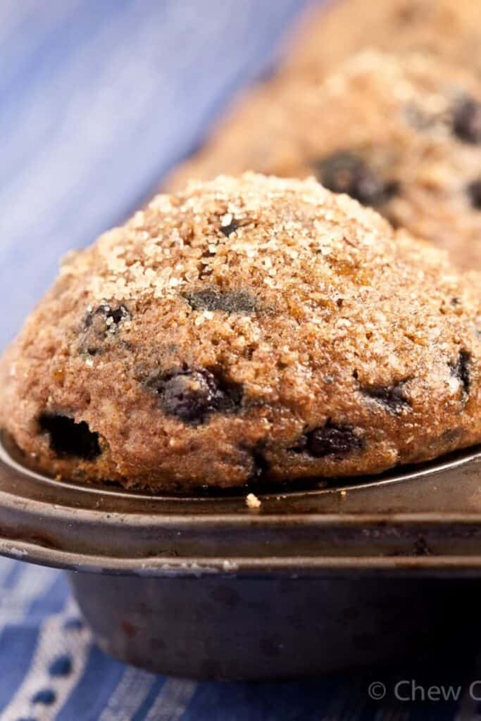 Close up of a healthy oatmeal blueberry muffin in a muffin tin. 