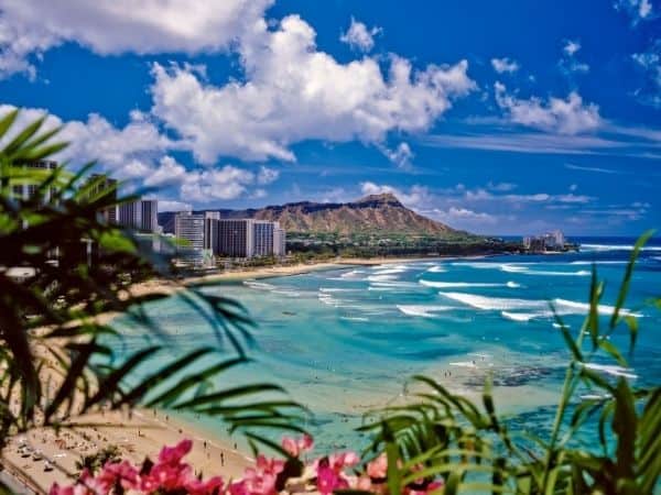 View of beach and ocean at Waikiki Beach, Honolulu. Hotels and Diamond Head in the distance.