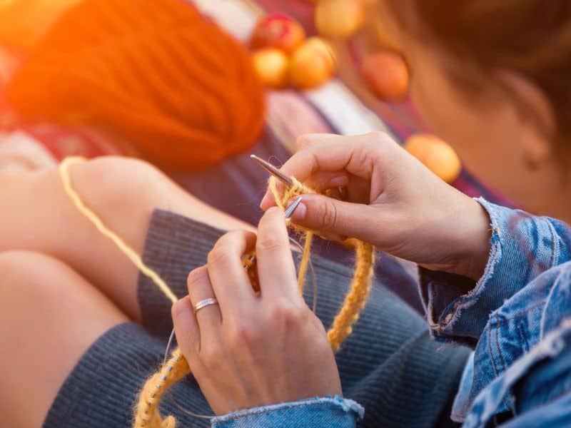 Woman's hands knitting a hat. 