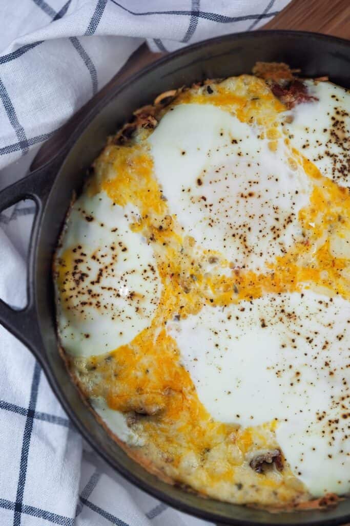 Mountain man casserole with eggs, sausage, cheese in a cast iron Dutch Oven pan.