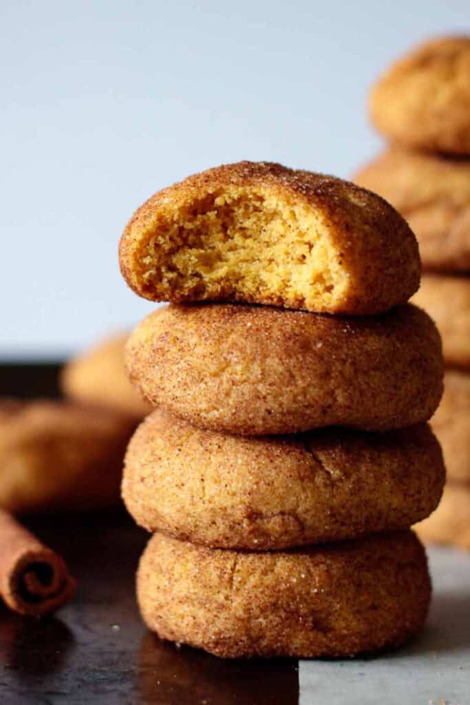 Stack of 4 mini pumpkin snickerdoodles, the top on with a bite taken out of it.