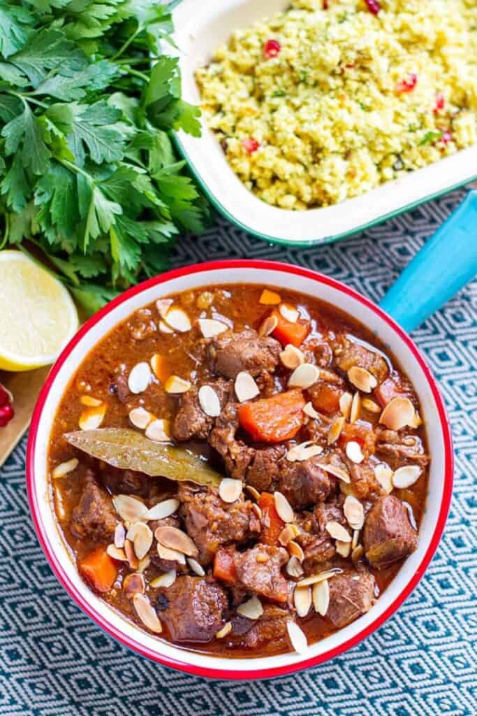 Bowl of Morroccan tagine, with carrots, lamb and sprinkled with sliced almonds.