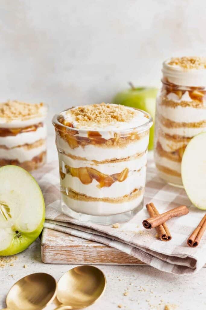 No Bake Apple Pie Parfaits layered with creamy filling, cinnamon spiced apples, and graham cracker crumbs in individual glasses for No Bake Apple Pie Parfaits layered with creamy filling, cinnamon spiced apples, and graham cracker crumbs in individual glasses for fast fall desserts.