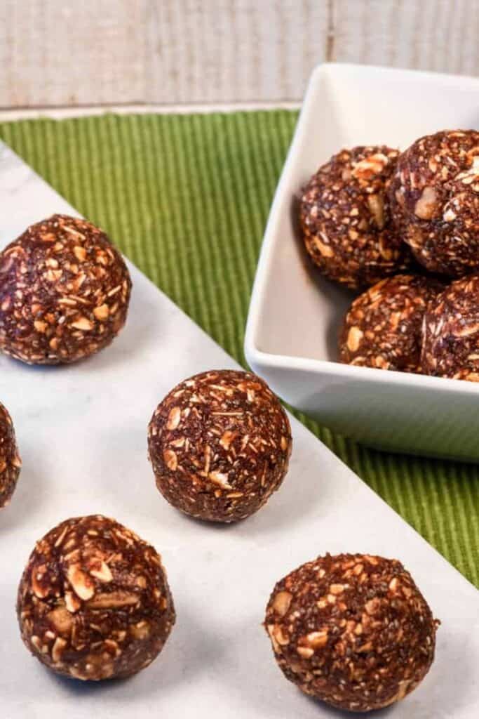 A square bowl and rectangular plate filled with no bake brownie balls. 