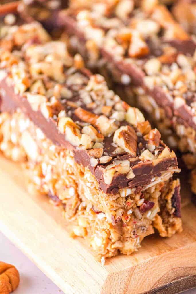 Close up of two rectangle pieces of chocolate covered, no bake geranola bars. 